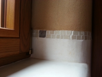 Mezi ručně hlazenými vodě odolnými omyvatelnými omítkami (marocký štuk "Tadelakt") a hliněnými omítkami je ručně skládaná mozaika z kouskú mramoru.