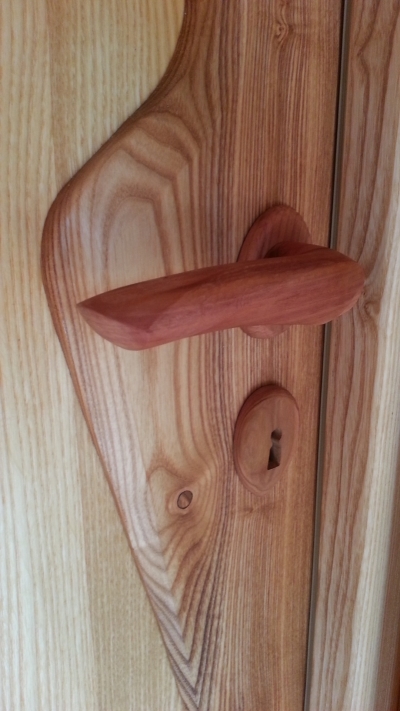 Detalle de la puerta de madera de fresno y tirador de madera de ciruelo.